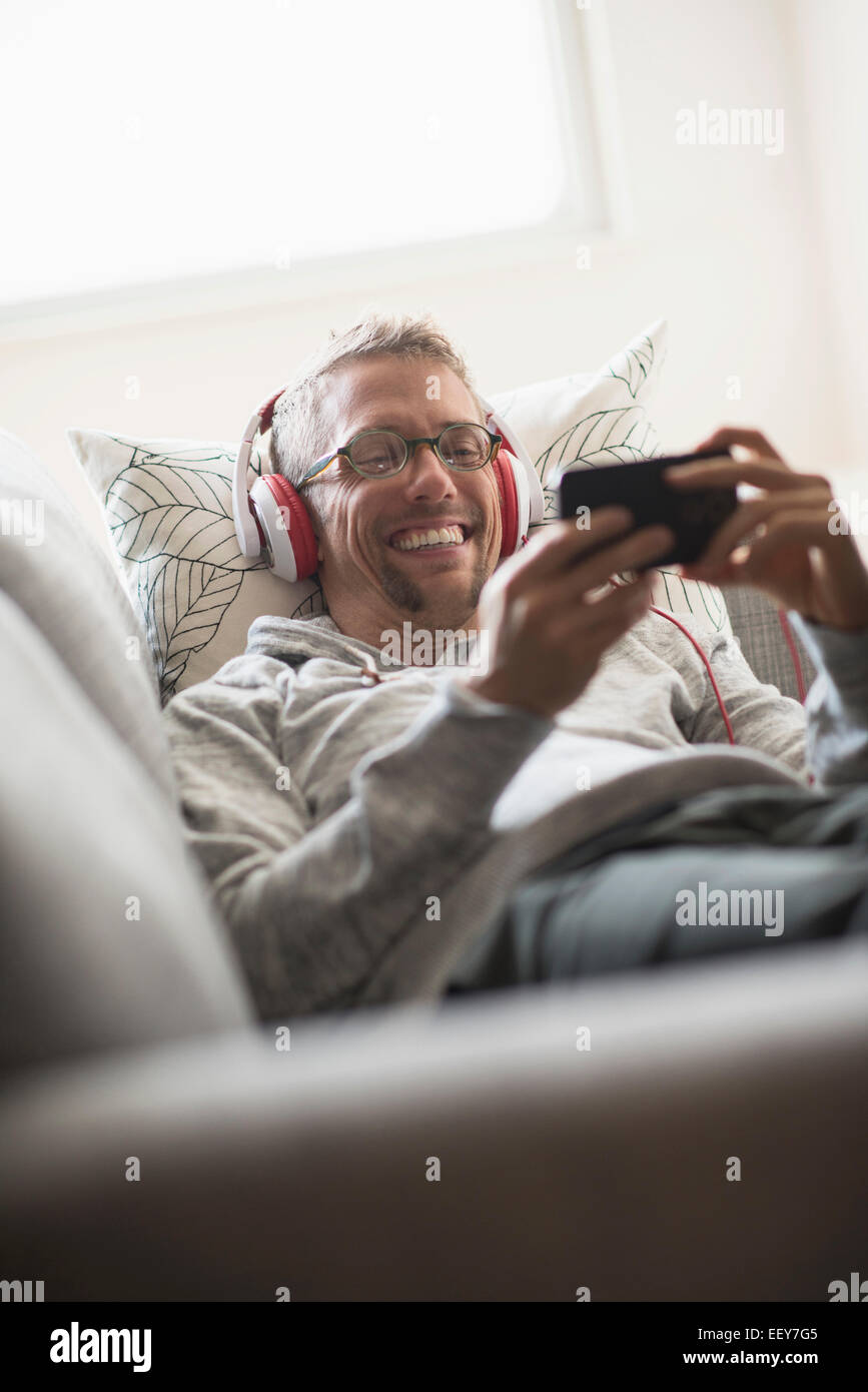 Mann auf Sofa anhören von Musik Stockfoto
