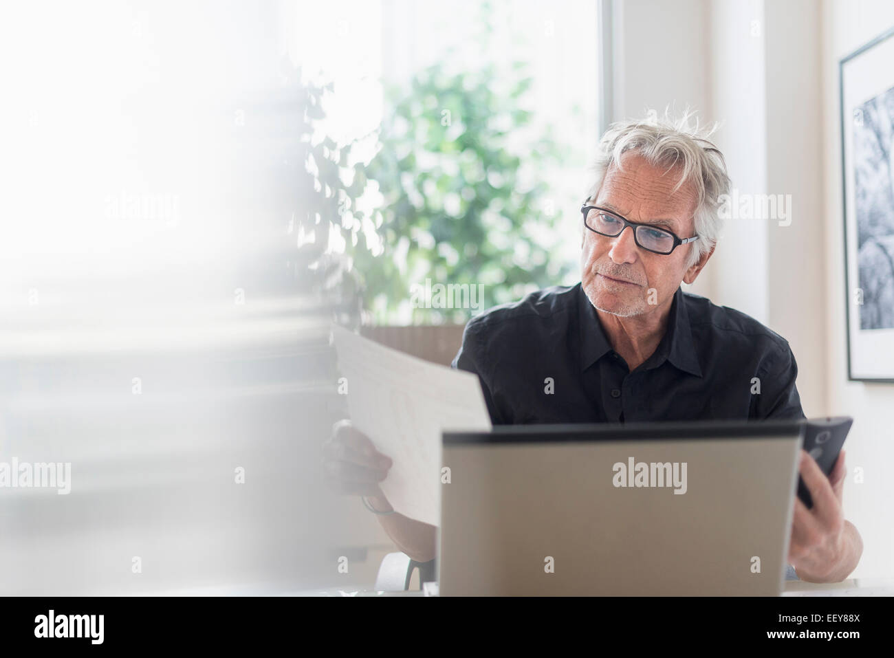 Ältere Mann sitzt im home-Office und Laptop verwenden Stockfoto