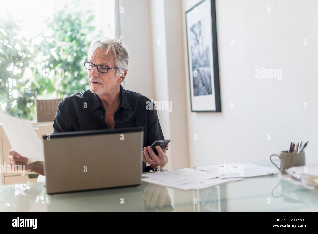 Ältere Mann sitzt im home-Office und Laptop verwenden Stockfoto