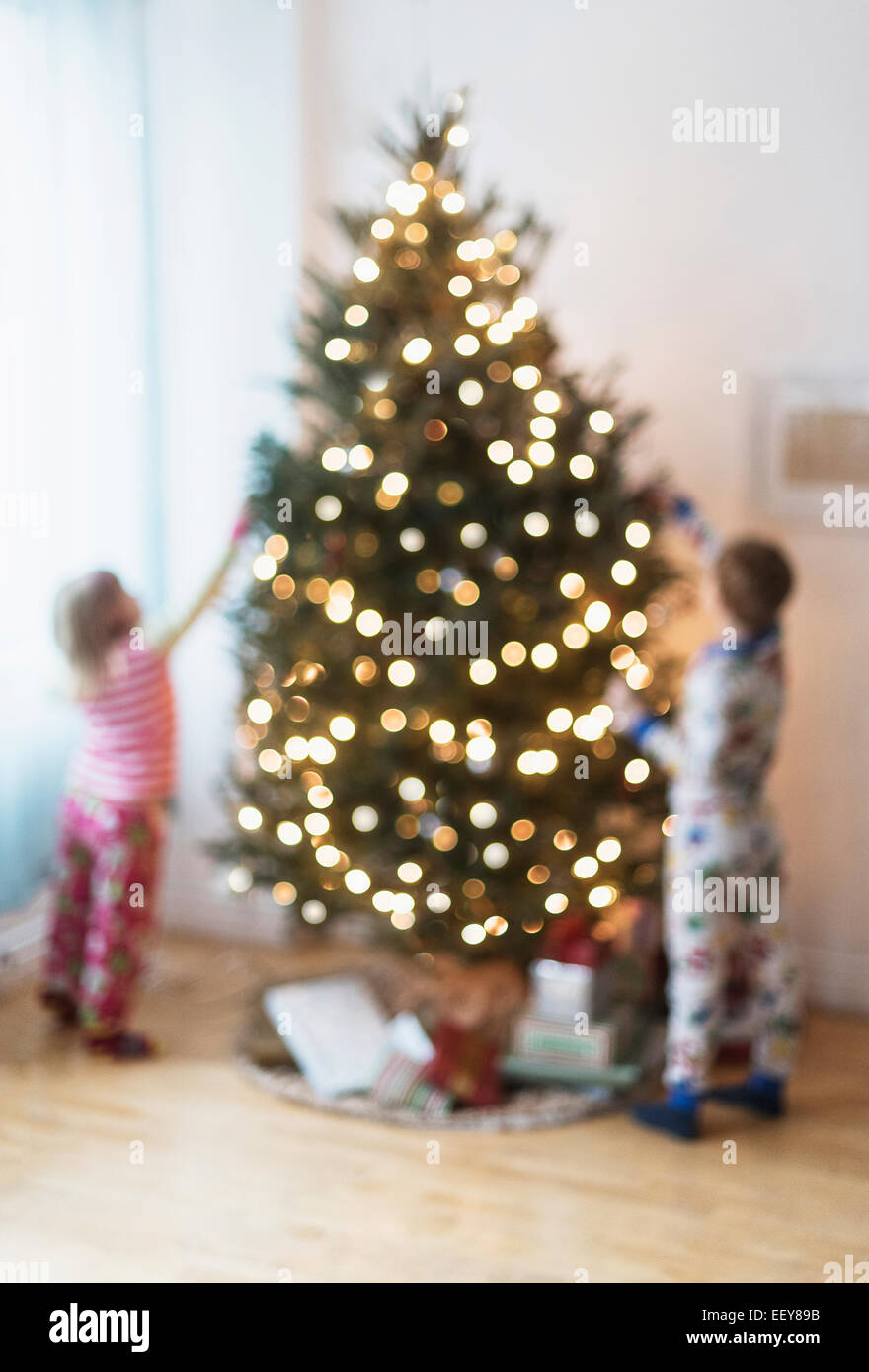 Schwester und Bruder (4-5, 6 und 7) dekorieren Weihnachtsbaum Stockfoto