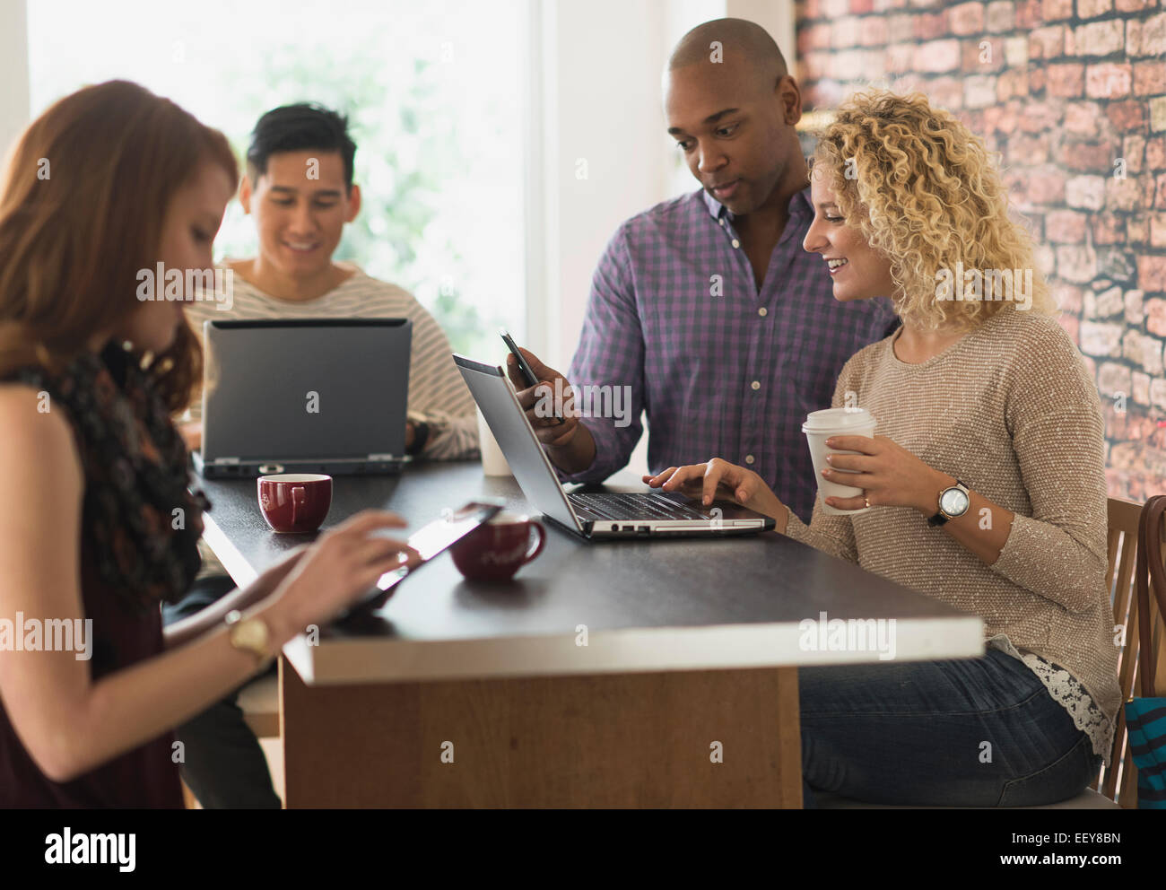 Freunde im Café sitzen mit Laptops und digitalen Tabletten Stockfoto