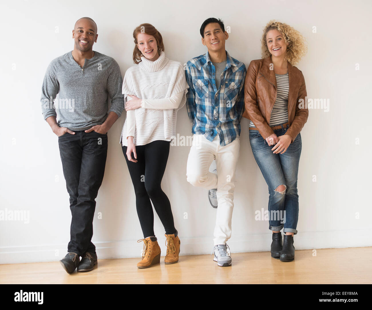 Gruppe von Freunden vor weißer Wand Stockfoto
