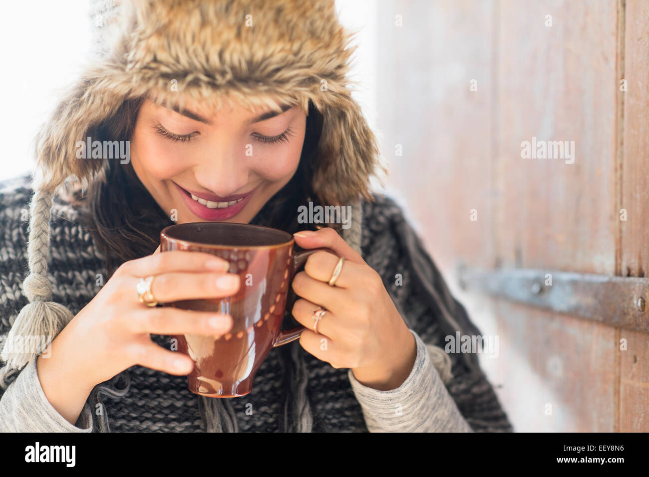 Porträt der lächelnde junge Frau trinken aus Becher Stockfoto