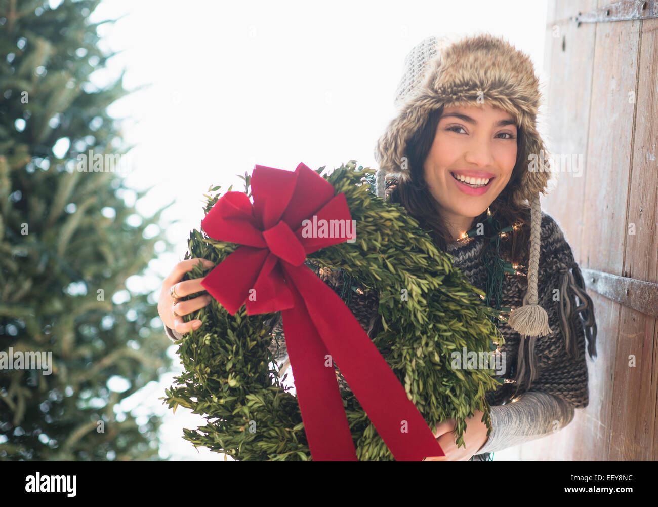 Porträt der jungen Frau hält Weihnachtskranz Stockfoto