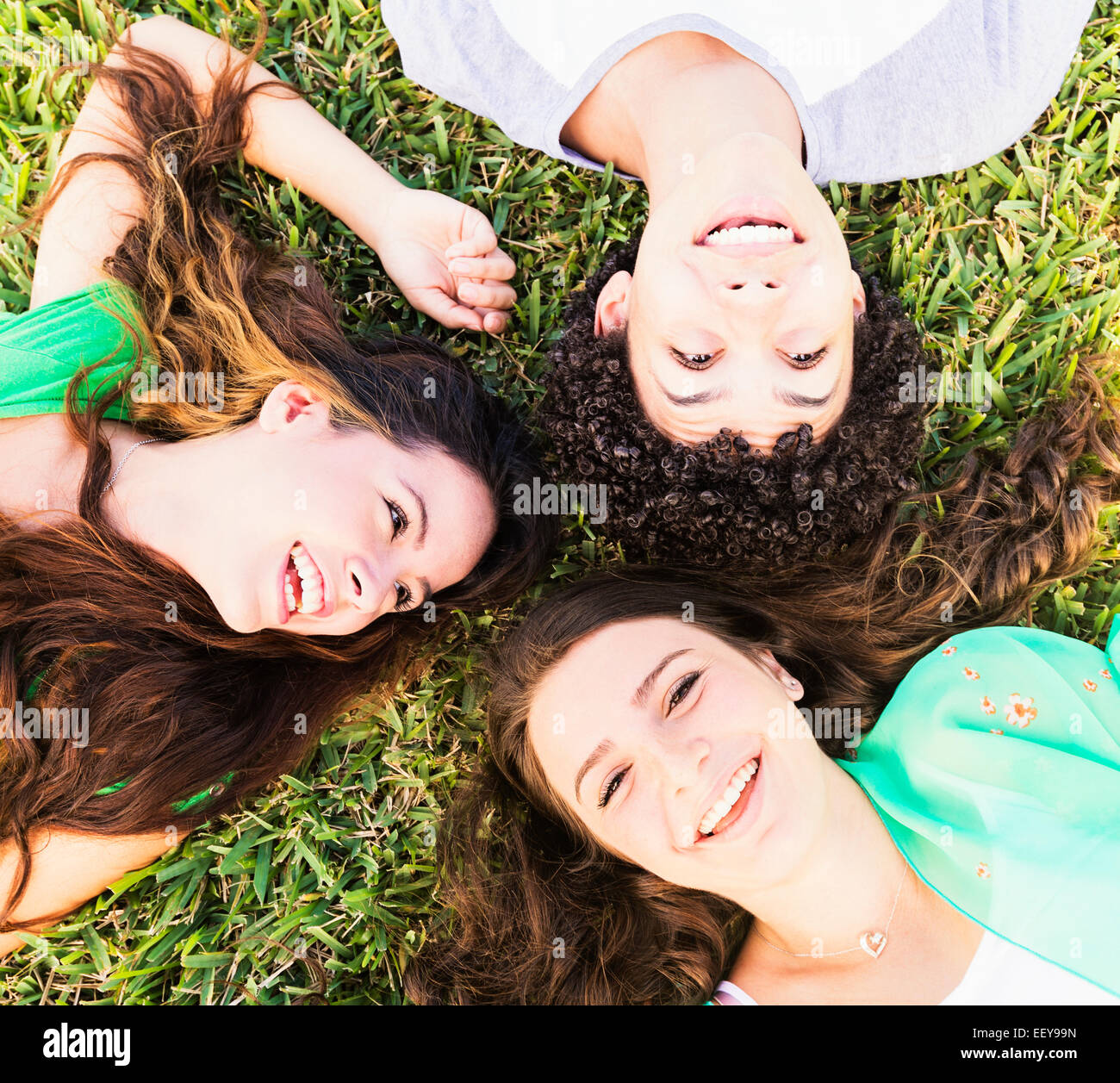 Porträt von Freunden (14-15) liegen auf dem Rasen Stockfoto