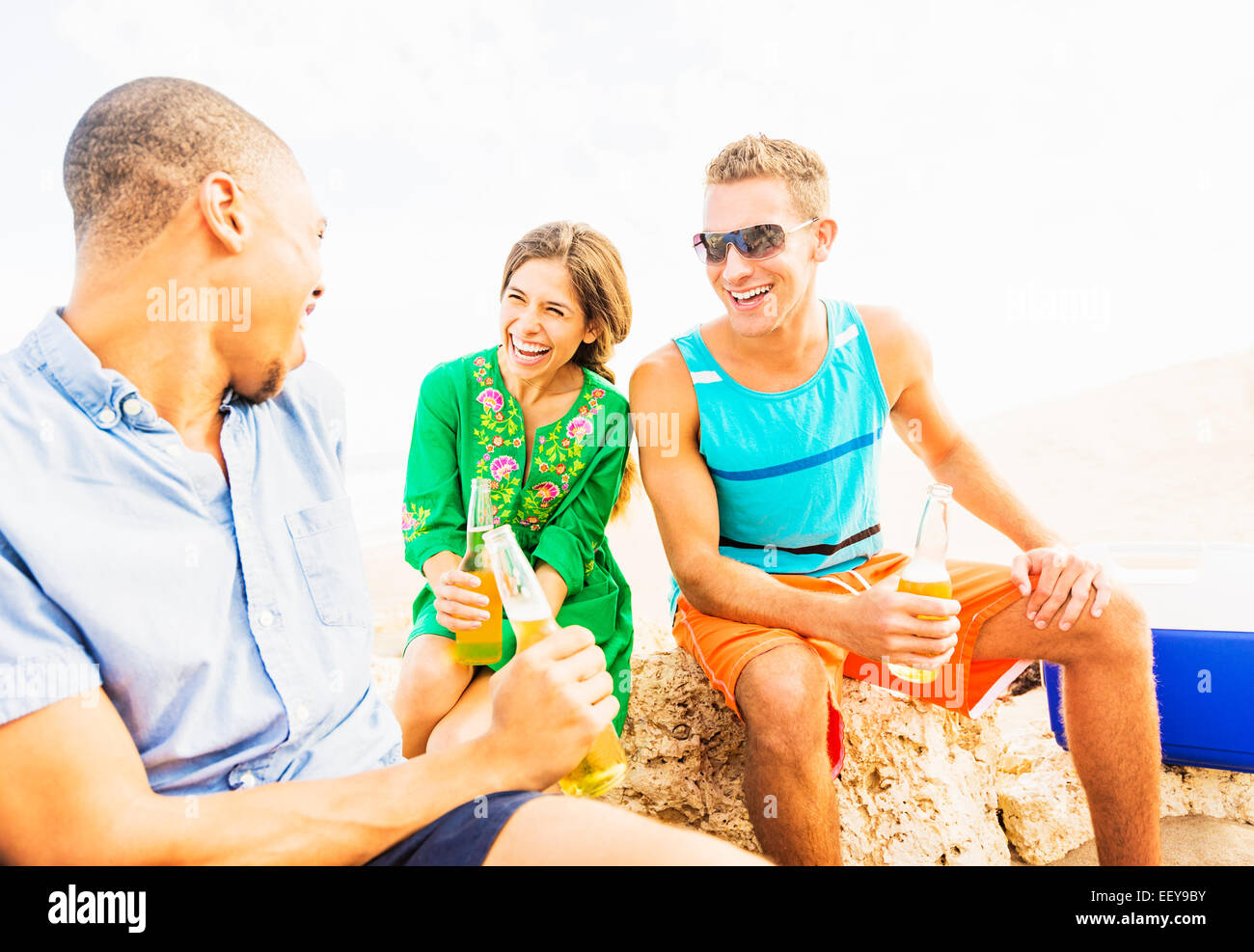 Junge Menschen, die Bier trinken am Strand Stockfoto
