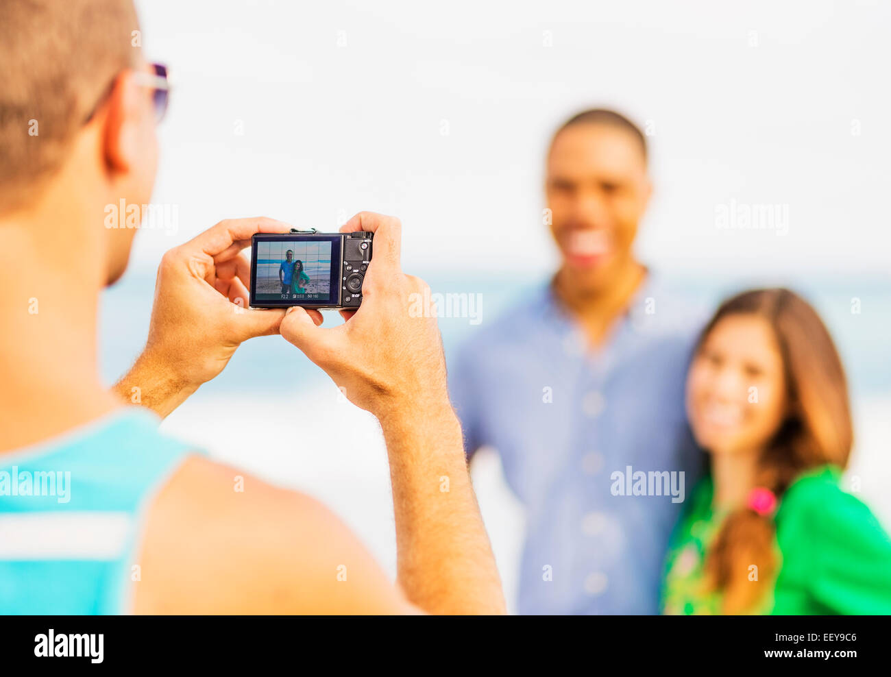 Junger Mann nehmen Foto des Paares am Strand Stockfoto