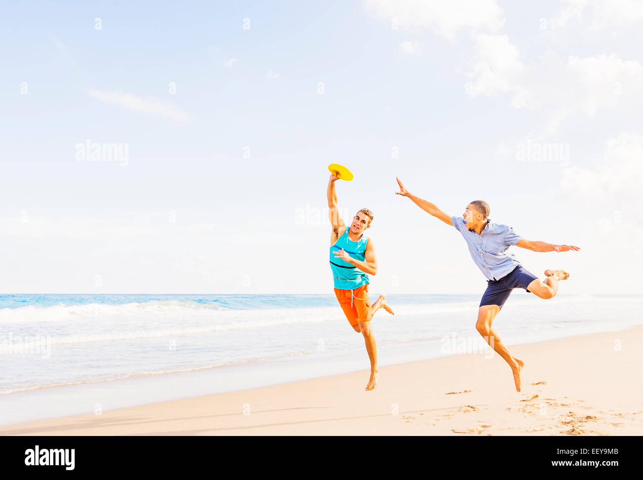 USA, Florida, Jupiter, junge Männer spielen Kunststoffscheibe am Strand Stockfoto