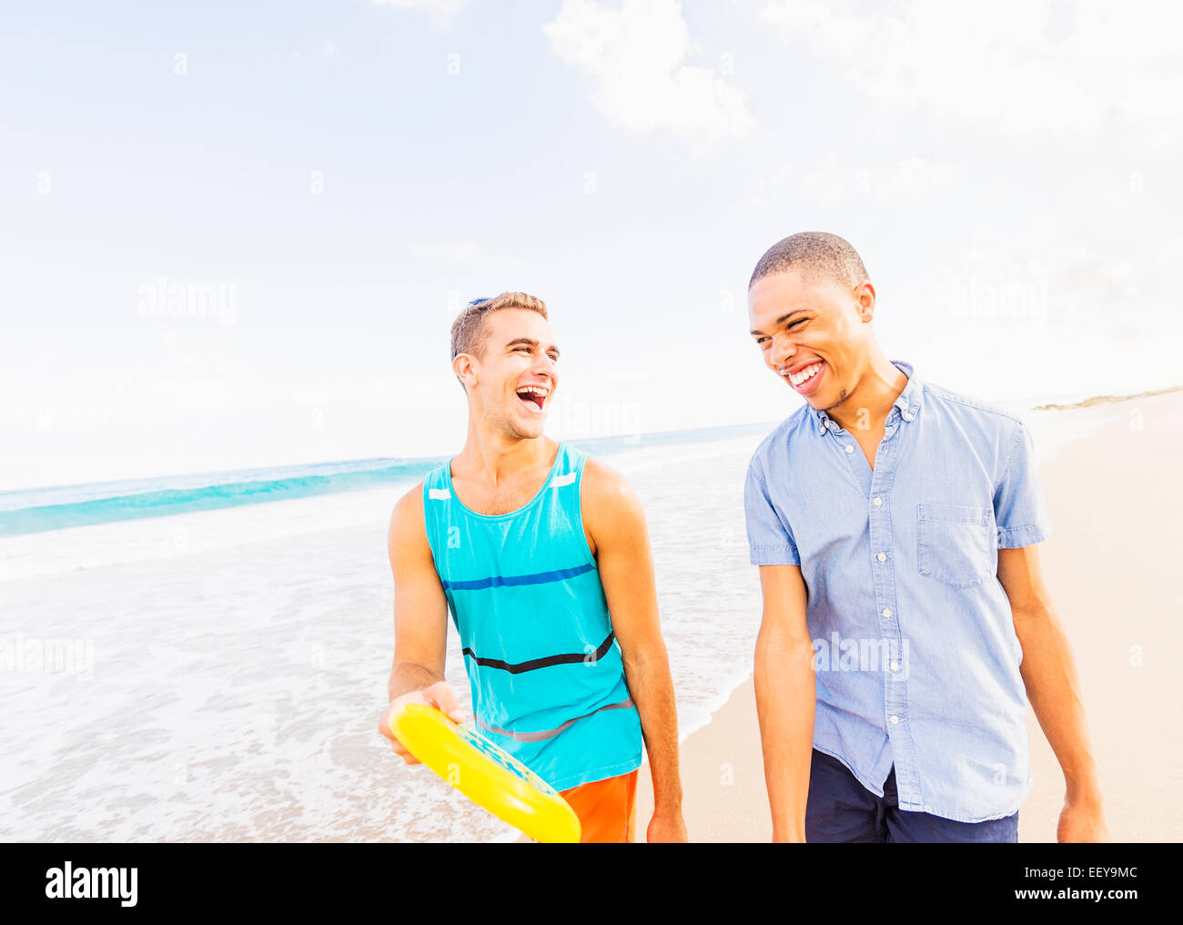 USA, Florida, Jupiter, junger Mann gehen und sprechen, mit Kunststoff-Scheibe am Strand Stockfoto