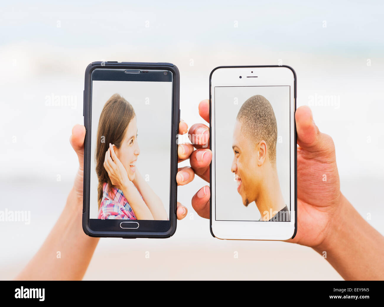 Hände halten Smartphones mit Bildern von jungen Menschen Stockfoto