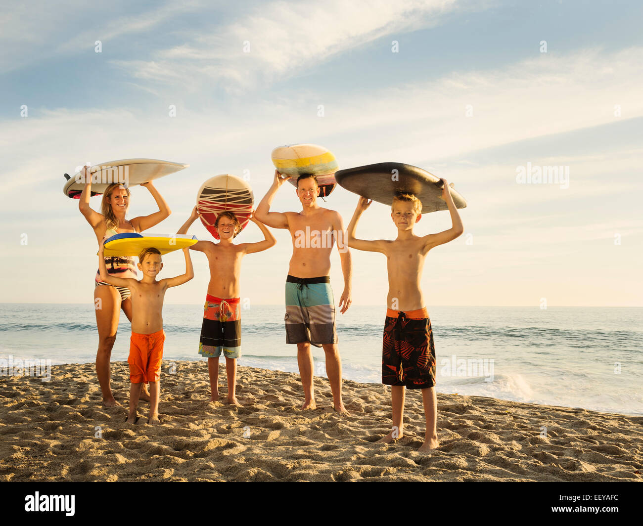 Porträt der Familie mit drei Kindern (6-7, 10-11, 14-15) mit Surfbrettern am Strand, Laguna Beach, California, USA Stockfoto