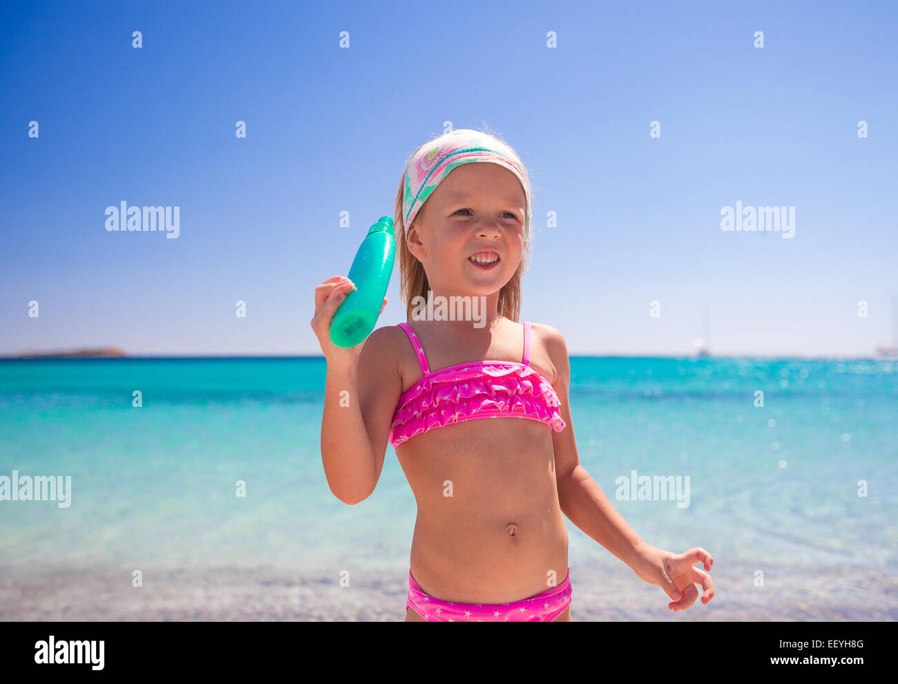 Entzückende Mädchen im Badeanzug mit Suntan Lotion Flasche Stockfoto