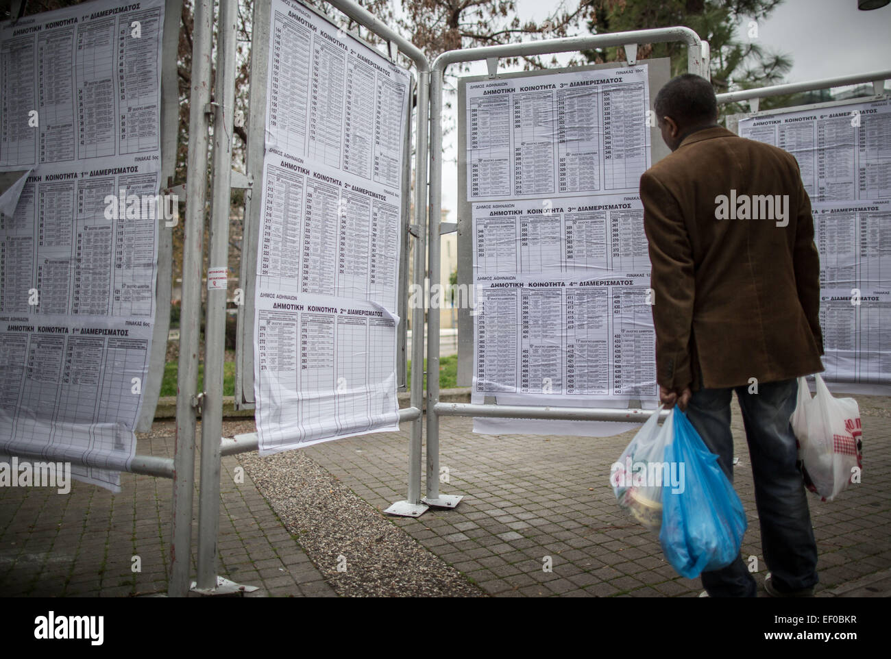 Ein Mann schaut auf einem Stimmzettel Poster mit den Kandidaten für die Wahl in Athen, 24. Januar 2015. Griechenlands linke, gegen Sparpolitik Syriza Partei und ihre Führer Alexis Tsipras, hat seinen Vorsprung an der Spitze für die 25. Januar 2015 Wahlen-Reiten eine Welle der Wut über Sparmaßnahmen als Voraussetzung für eine internationale Rettungsaktion erweitert. Foto: Michael Kappeler/dpa Stockfoto