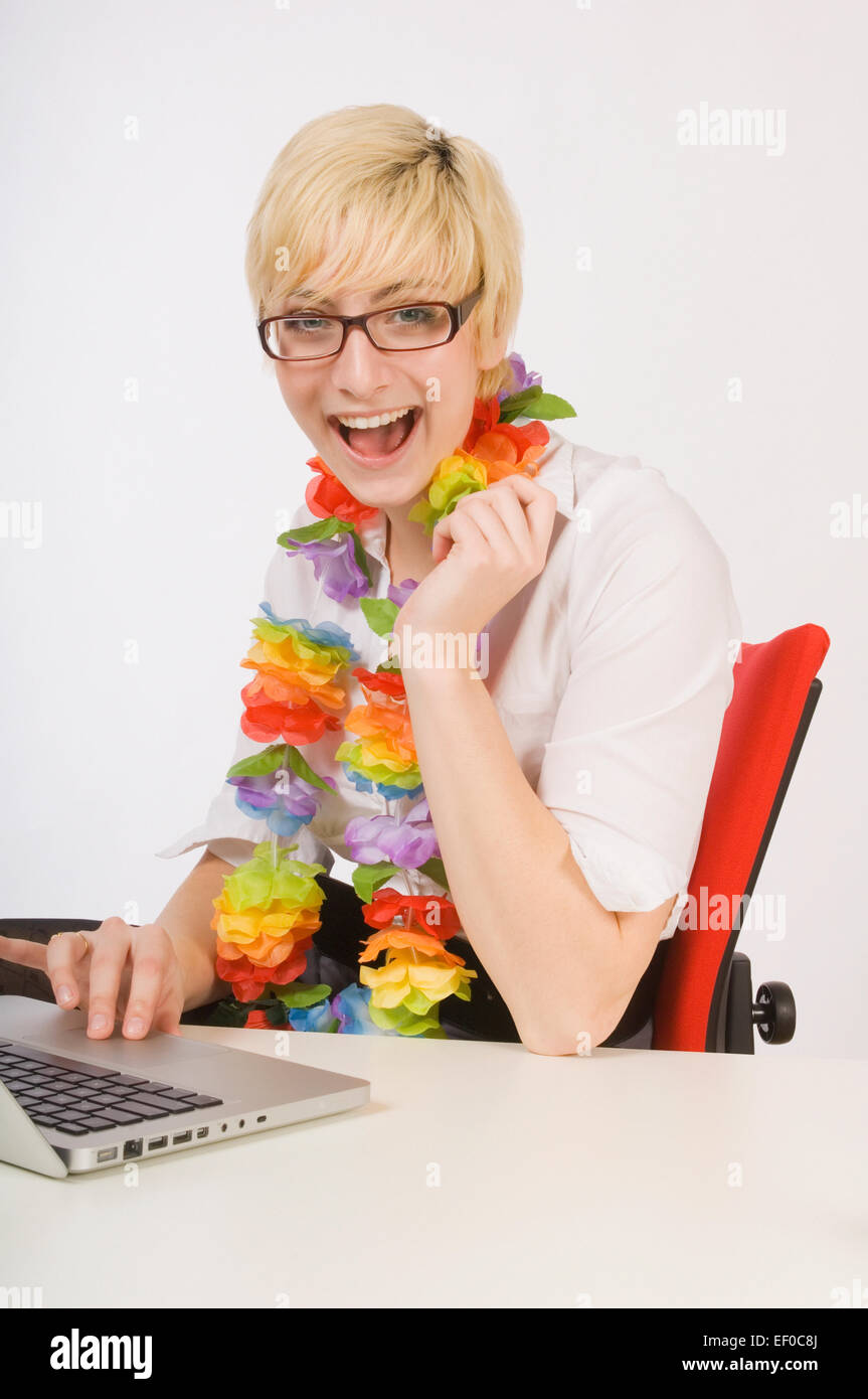 Blonde Frau sitzt am Schreibtisch tragen ein lei Stockfoto