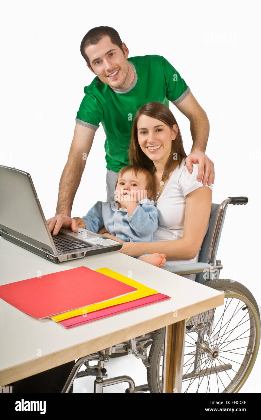 Eltern und ihr Baby sitzen am laptop Stockfoto