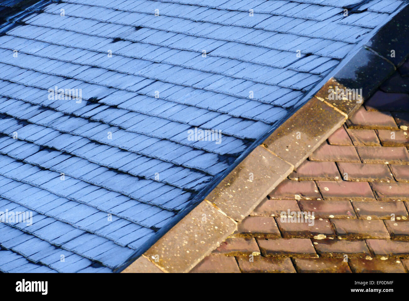 Am frühen Morgen, Dach mit Schiefer, einseitig abgedeckt bei Frost, geschmolzen andererseits der Frost von der Sonne. Stockfoto