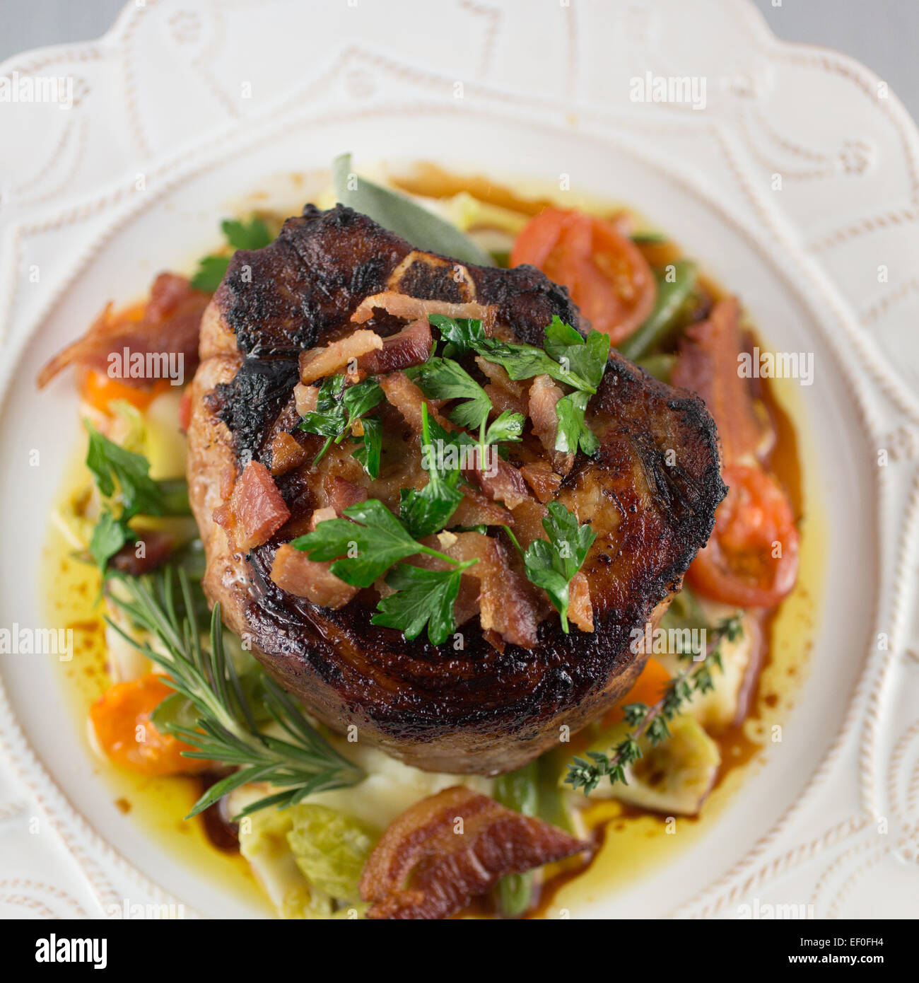 Berkshire-Kotelett mit Knoblauch Kartoffelpüree, Heirloom Tomaten und grüne Bohnen Stockfoto