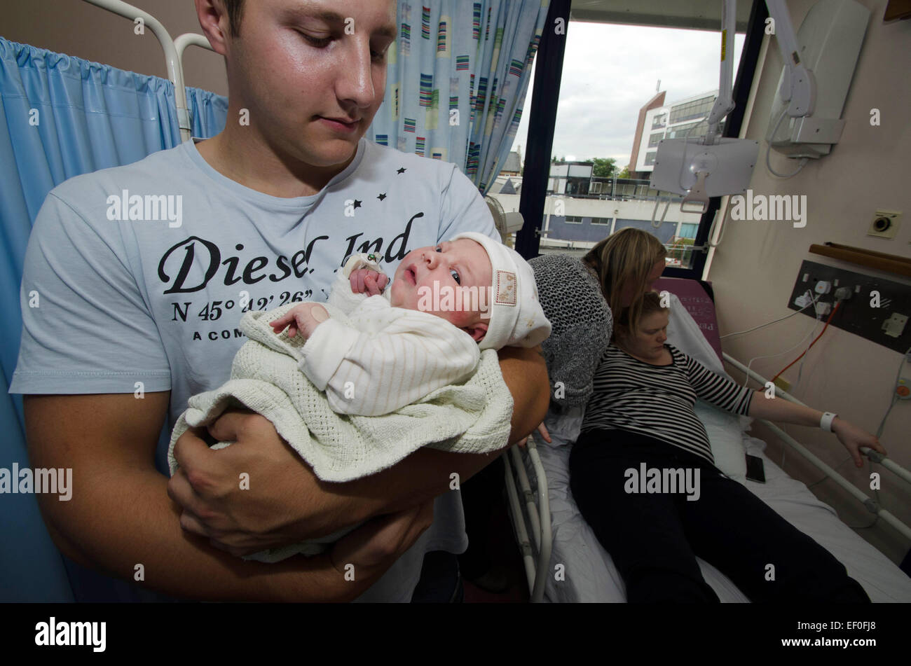 Eine erste Mal Vater hält sein Neugeborene Baby in einer Krankenstation. Stockfoto