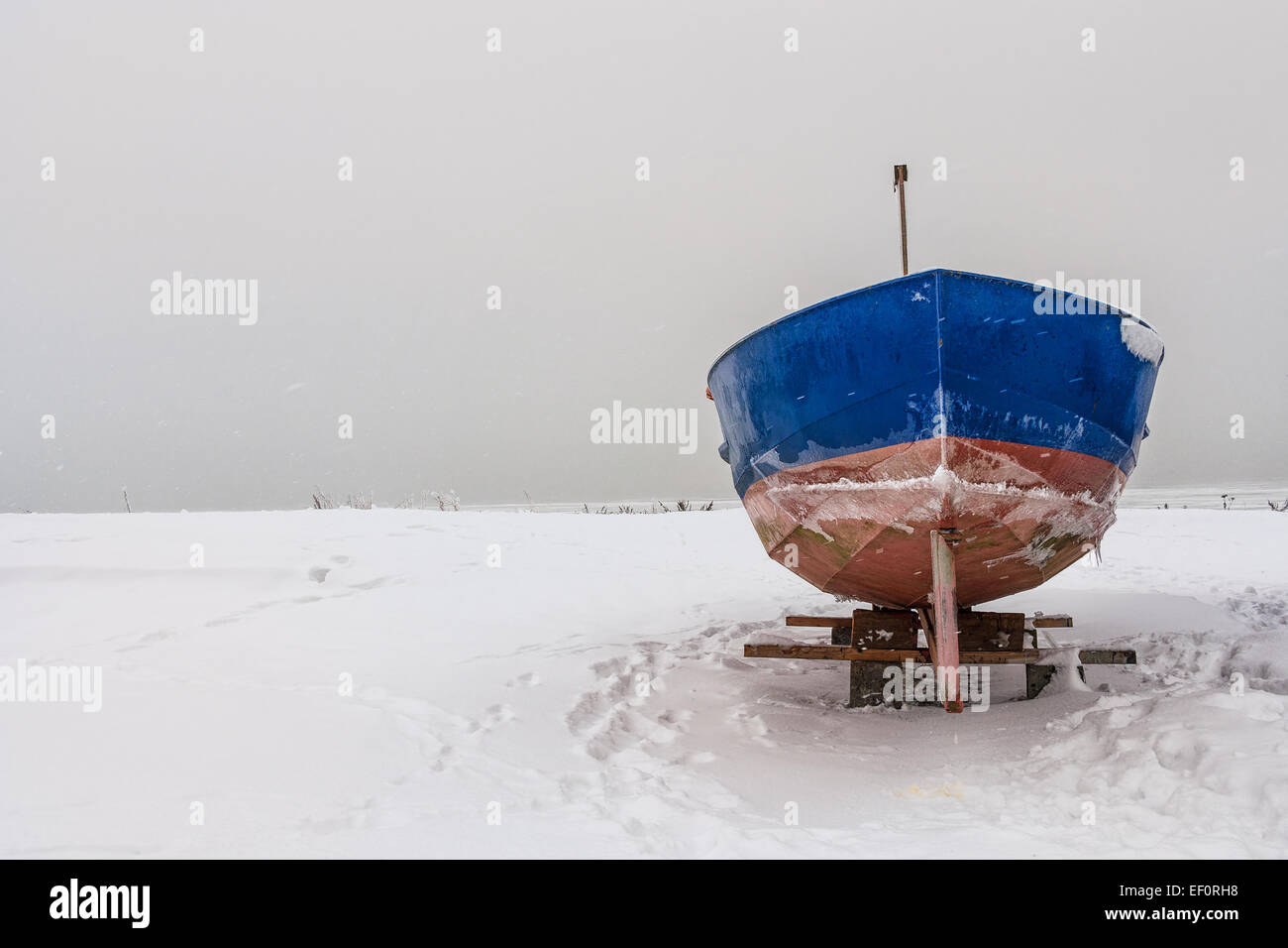 Ein Fischerboot am Ufer der Ostsee im Winter. Stockfoto