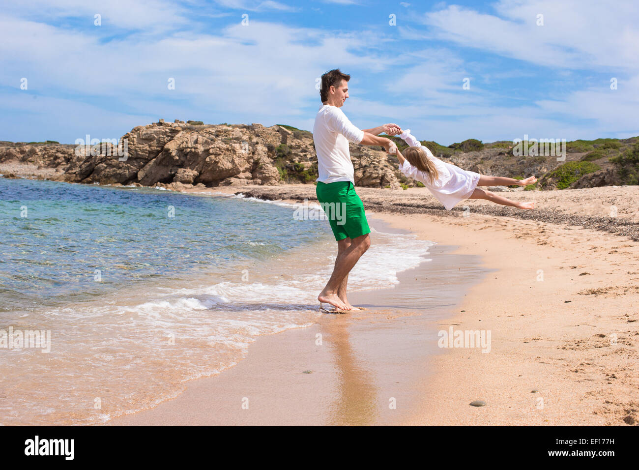 Glücklicher Vater und niedlichen kleinen Tochter viel Spaß im Urlaub am Strand Stockfotografie