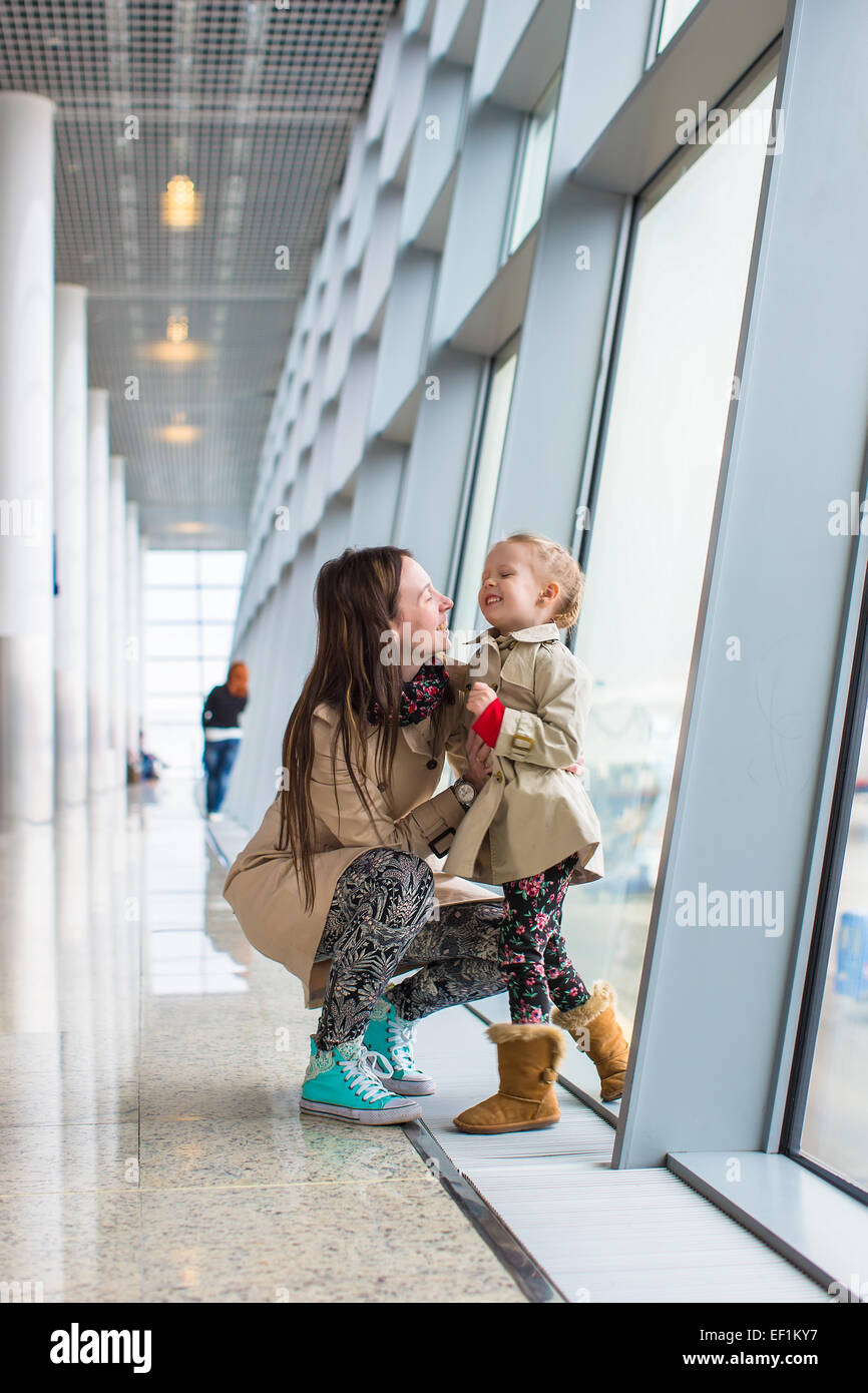 Mutter und Tochter schaut aus dem Fenster am Flughafenterminal Stockfoto