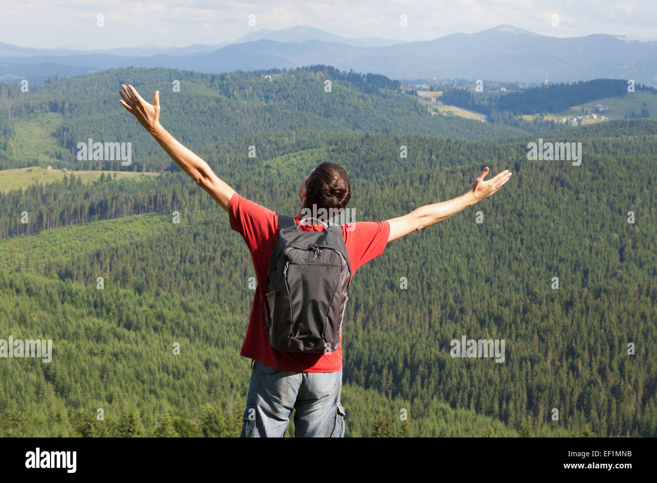 Glücklicher Mann mit Händen oben am Berg Stockfoto