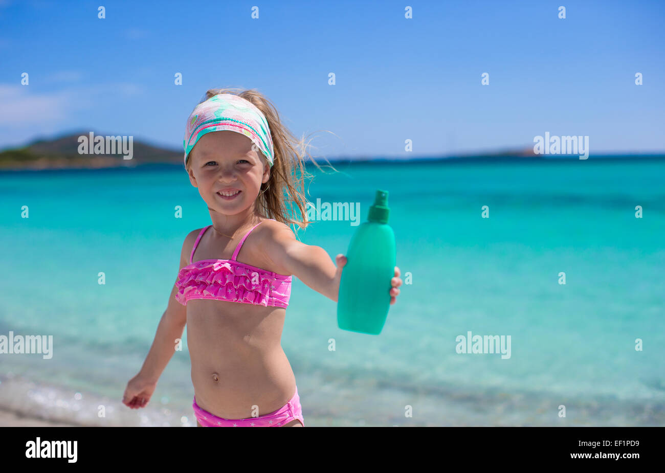 Entzückende Mädchen im Badeanzug mit Suntan Lotion Flasche Stockfoto