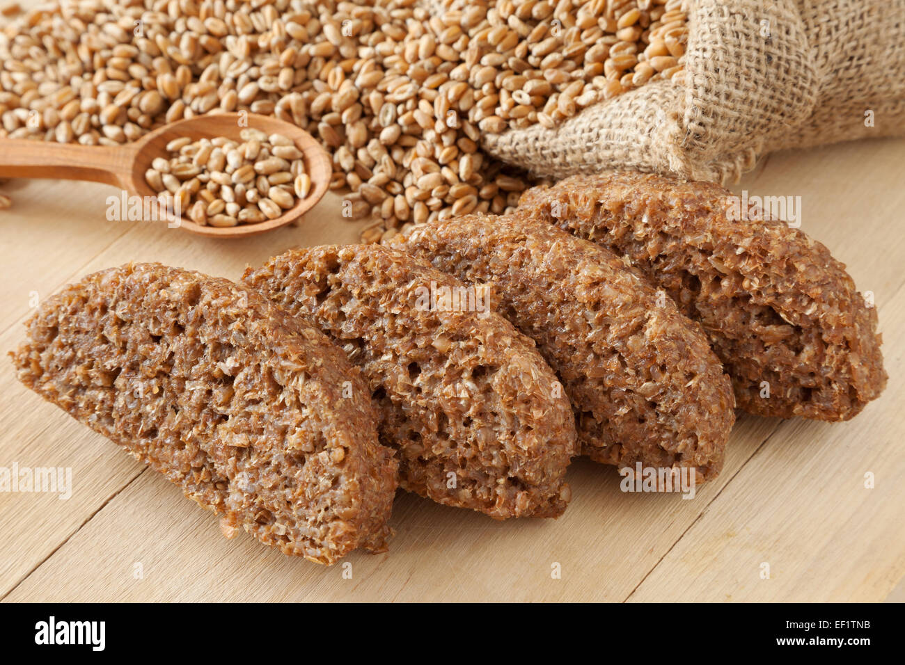 Brotscheiben aus Weizen-Sprossen und Samen im hessischen Tasche am Küchentisch Stockfoto