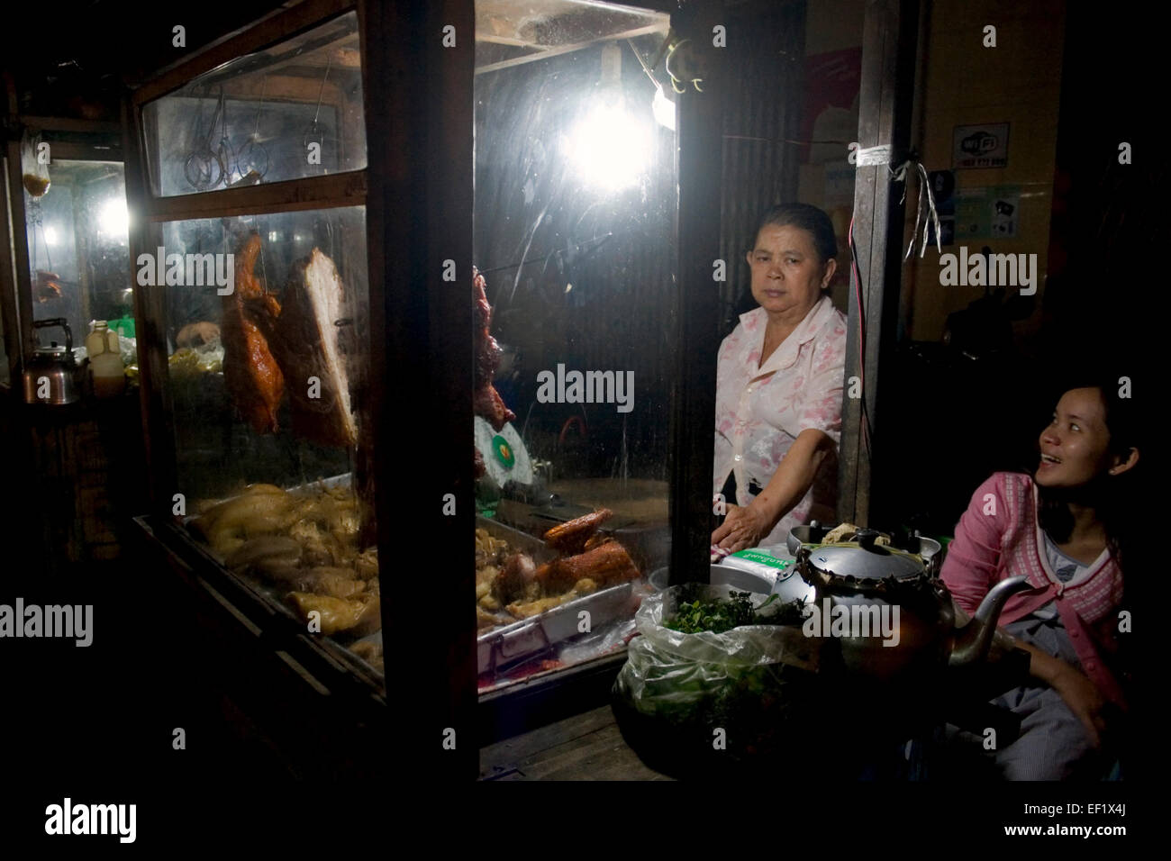 Eine Frau Straßenhändler arbeitet nachts Fleisch auf eine Stadt Straße in Kampong Cham, Kambodscha zu verkaufen. Stockfoto