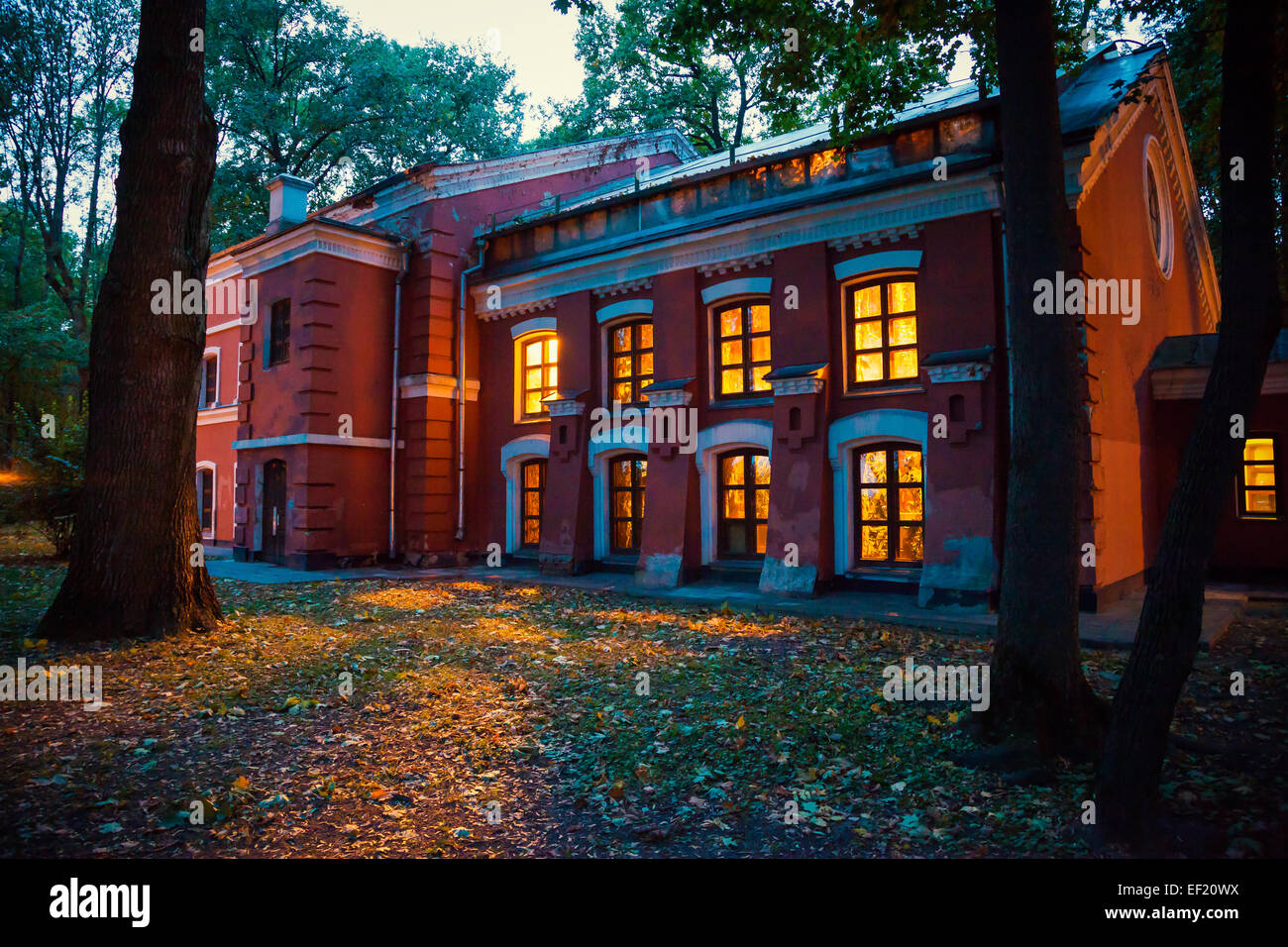 geheimnisvolle Halloween-Altbau mit gelben Licht vom Fenster in der Abenddämmerung Stockfoto