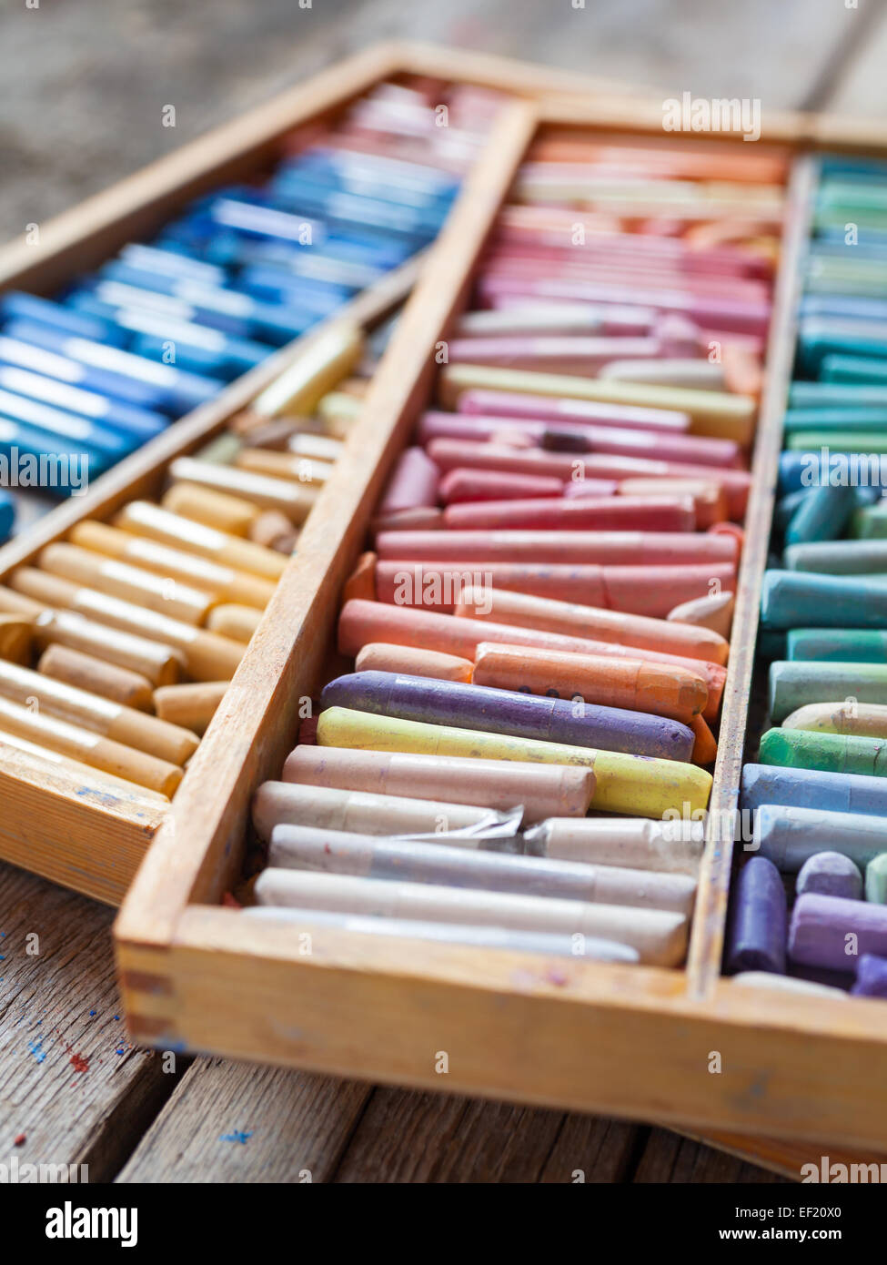 Reihe von bunten professionelle künstlerische Pastellstiften in offenen Holzkiste auf Tisch. Selektiven Fokus. Stockfoto