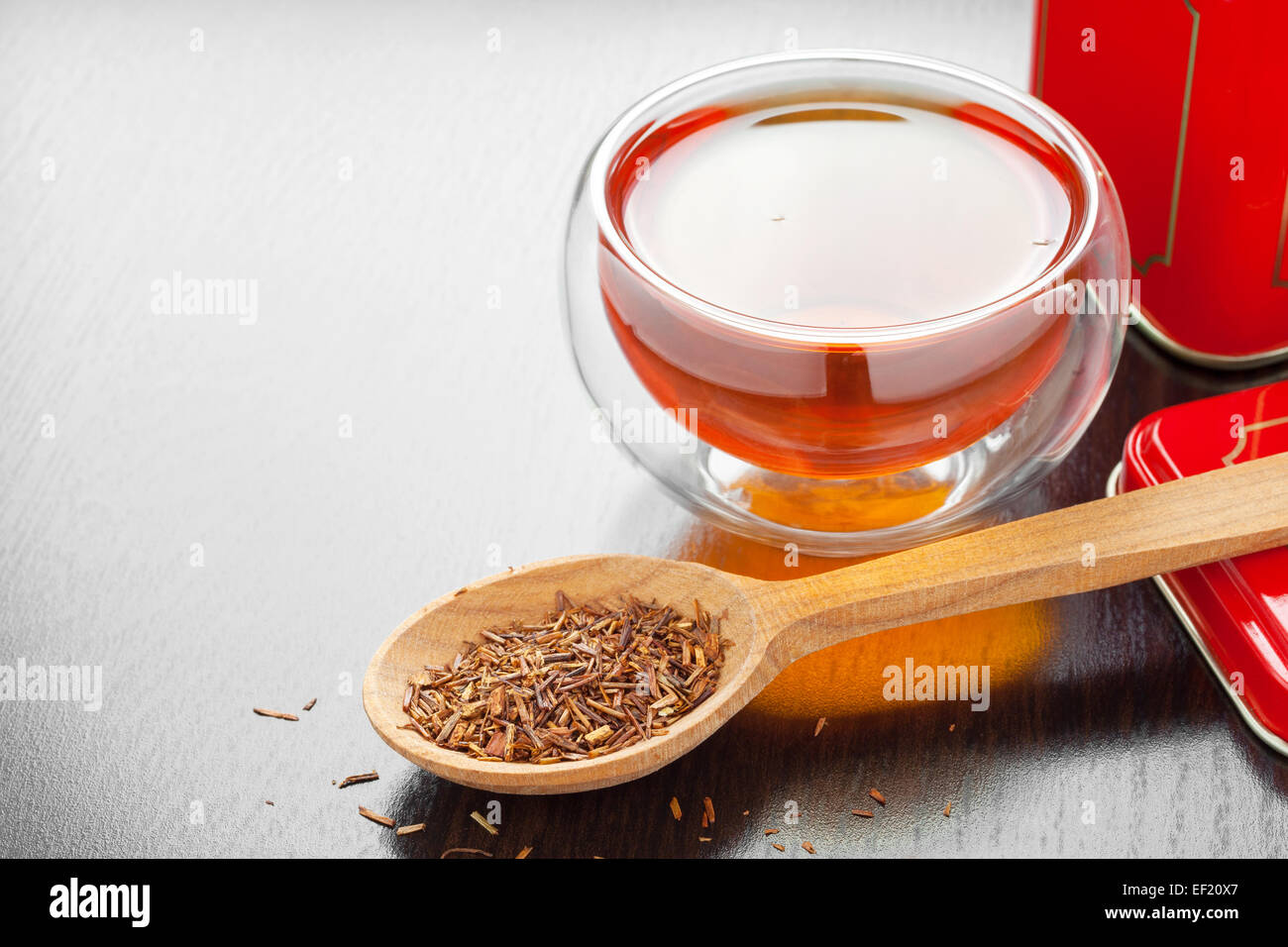 Rooibos in Löffel Closeup, zwei Teetassen und Tee Blechdose auf Küchentisch Stockfoto