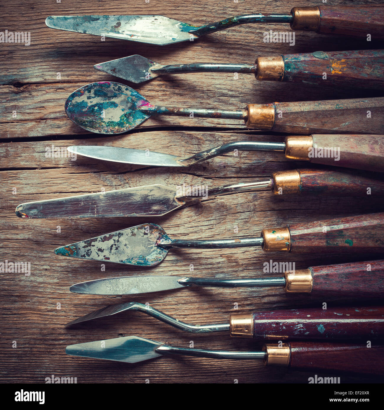 Zeile der Künstler-Palette Messer auf alten rustikalen Holztisch, Retro-stilisiert Stockfoto