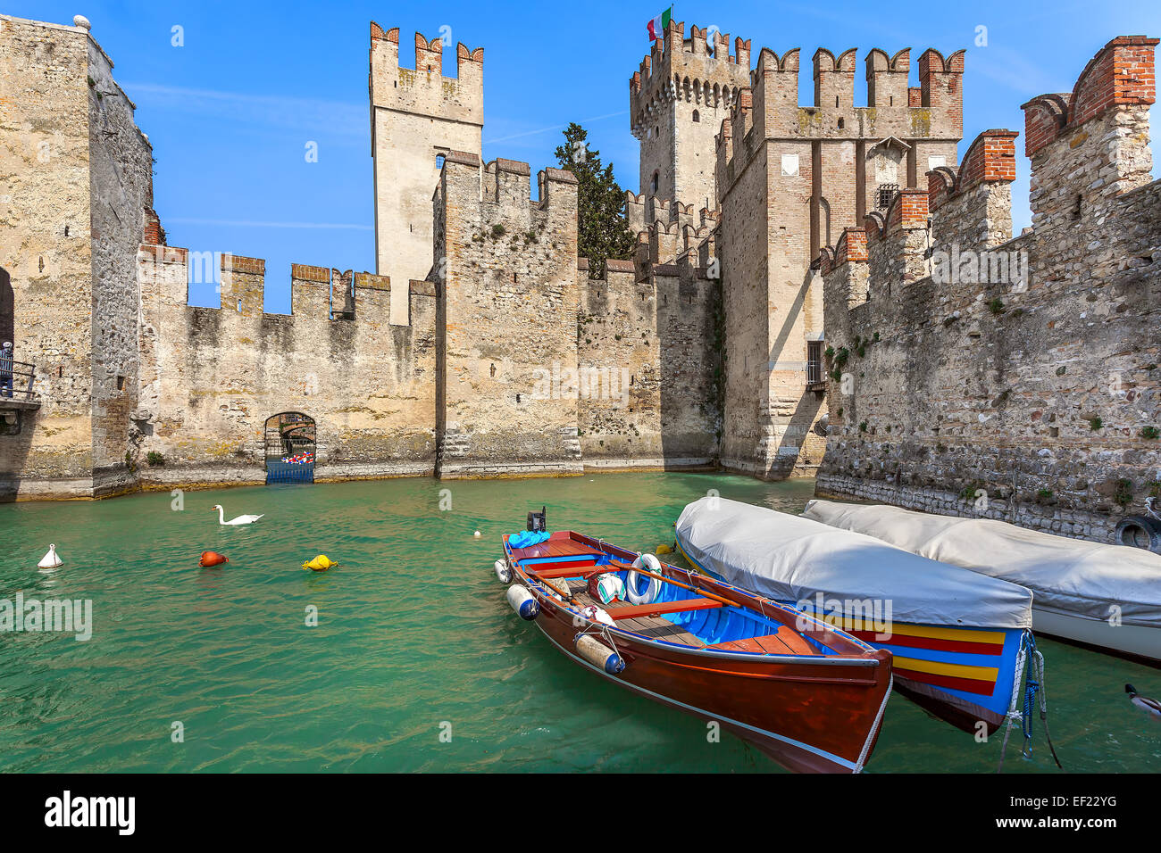 Boote am Gardasee und Scaliger Burg in der Stadt von Sirmione, Italien. Stockfoto