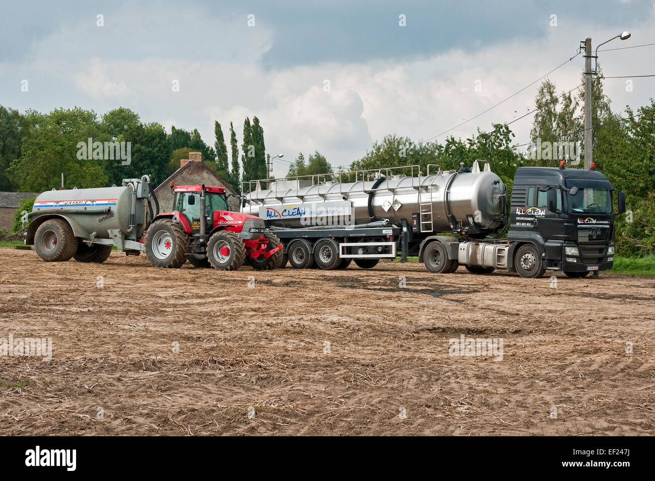 Tanker, die Übertragung von Abwasser auf Bauernhof Traktor und Anhänger vor Gülle Verbreitung auf Ackerflächen in Belgien Stockfoto
