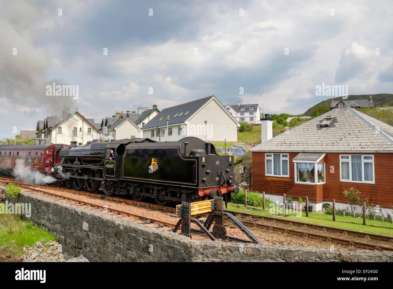 Jacobite Steam Train vorbei nah an Häuser auf West Highland Railway Linie nach Fort William. Mallaig Highland Schottland UK Großbritannien Stockfoto