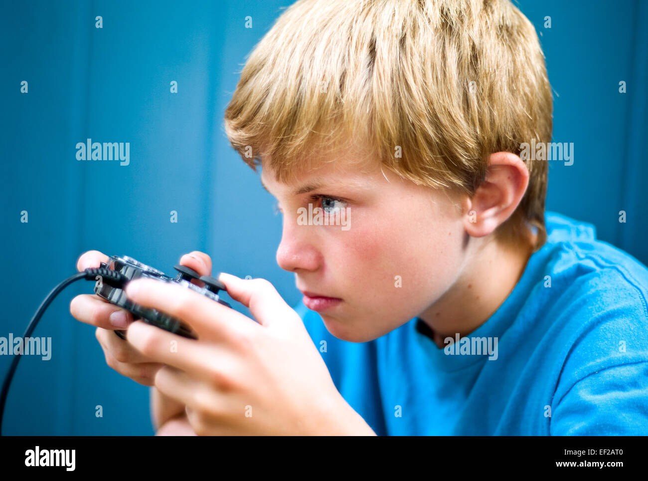 Junge, 10-11-12-13, Videospiel mit Controller mit Konzentration Stockfoto