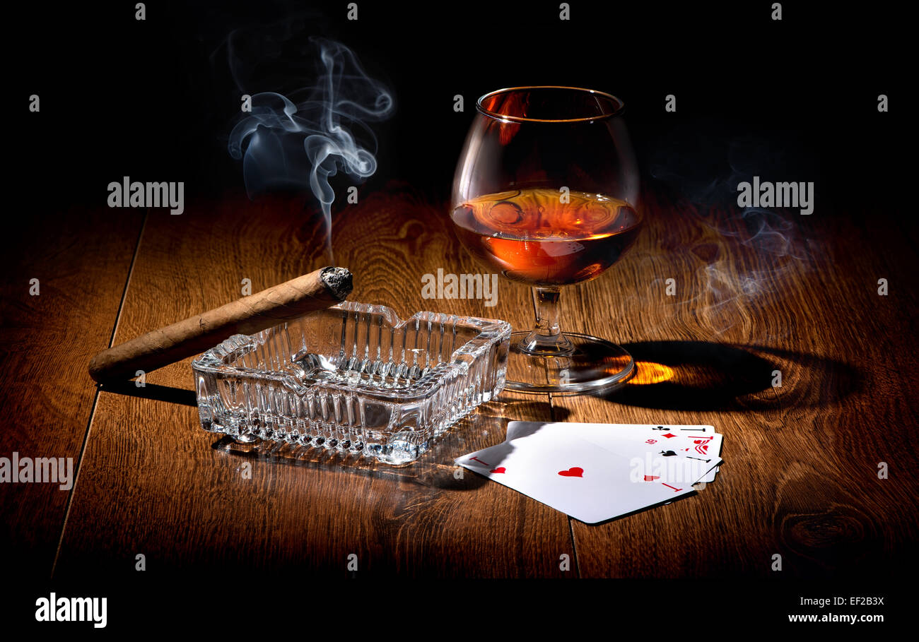 Spielkarten in der Nähe von Weinglas Whisky und Zigarre Stockfoto