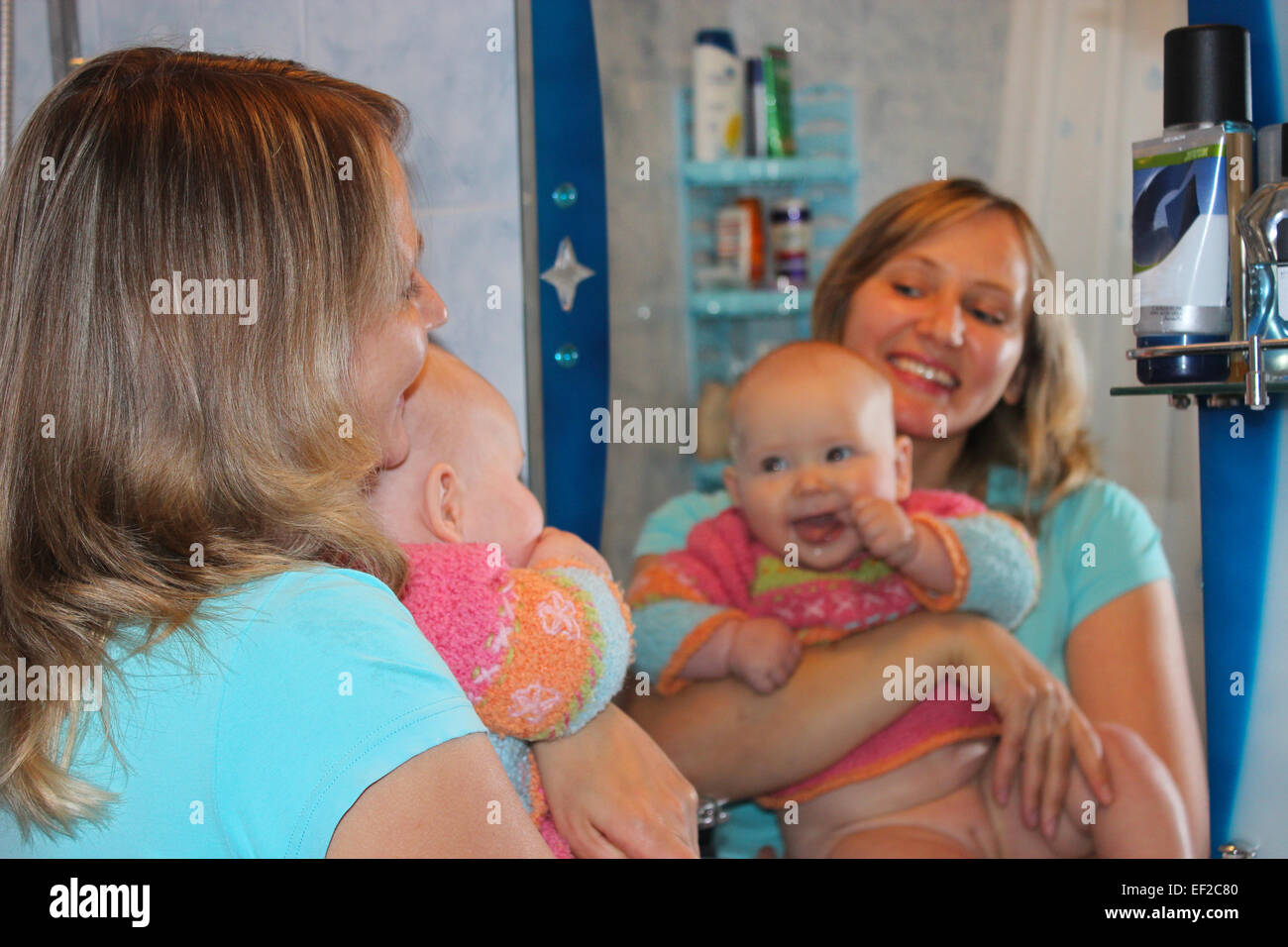 glückliche Mutter mit ihrer kleinen Tochter im Spiegel reflektieren Stockfoto