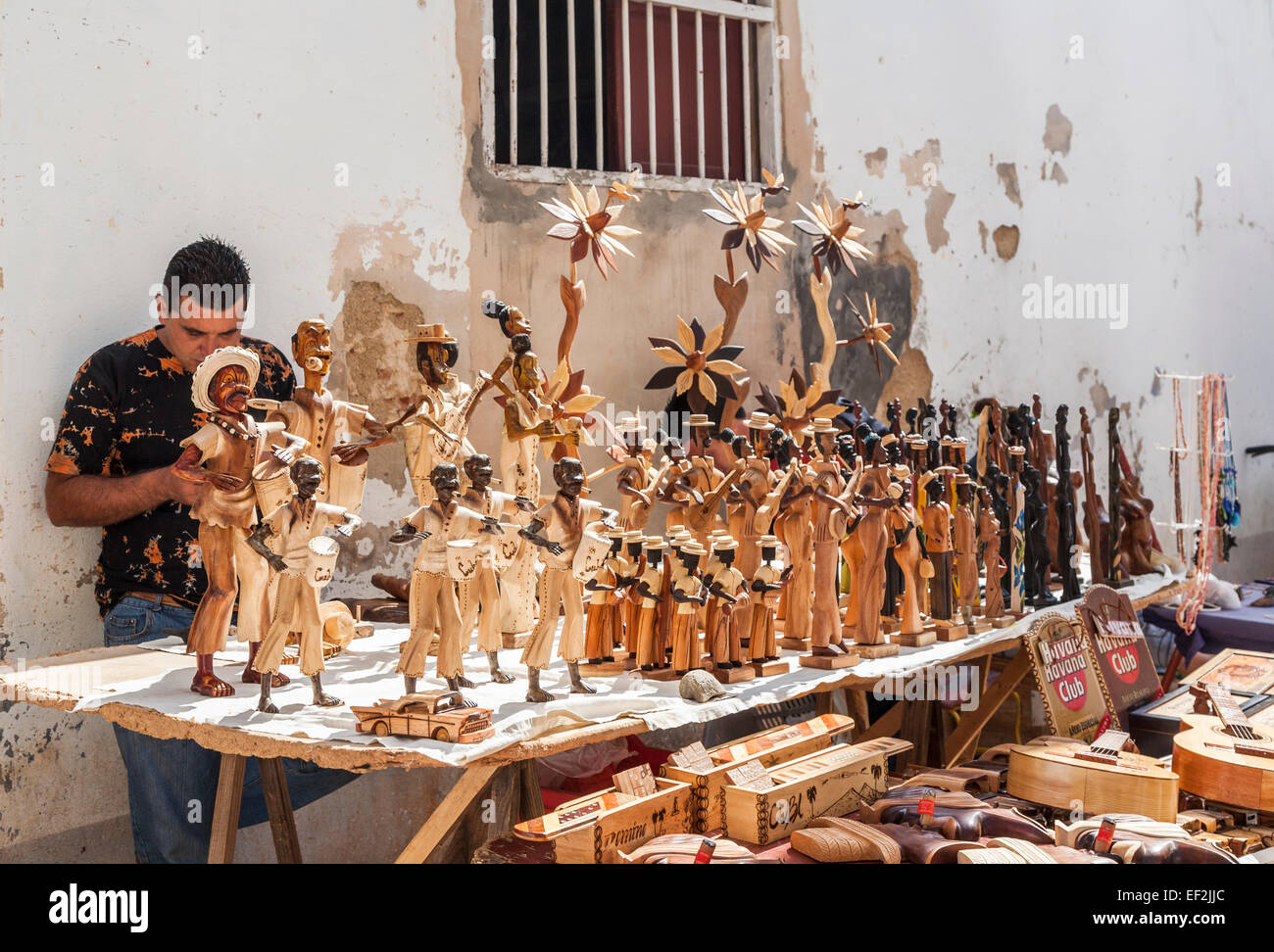 Kubanische lokalen Lebensstil: Lokale männliche Standbesitzer mit hölzernen Statuen von Menschen zum Verkauf als Souvenirs an einem Stand in der Innenstadt von Trinidad, Kuba Stockfoto