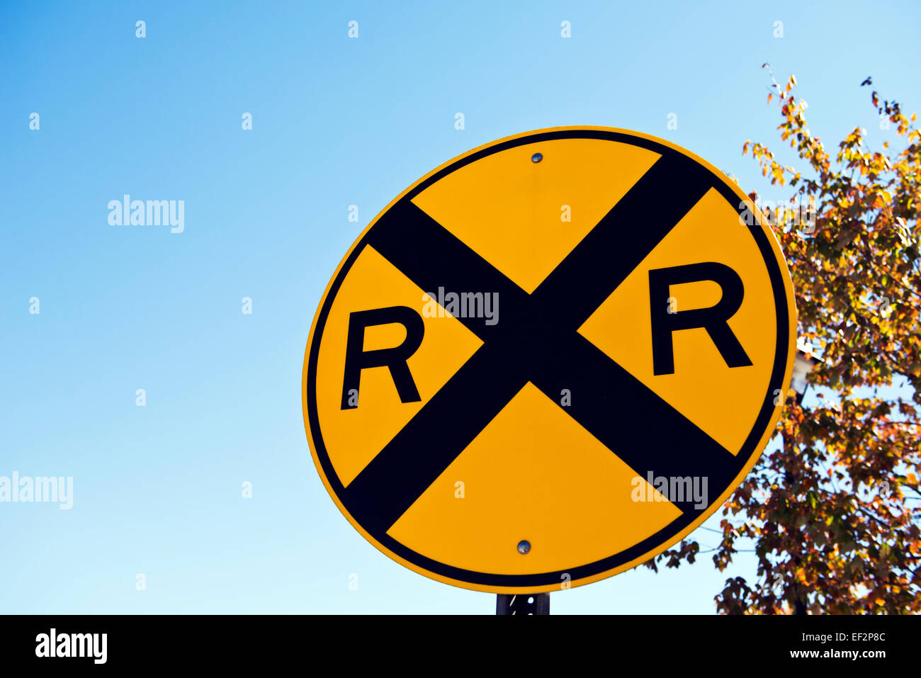 Railroad Crossing Zeichen gegen strahlend blauen Himmel Stockfoto