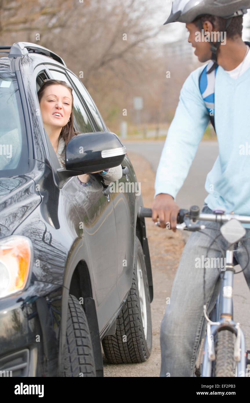 Frau im Auto, im Gespräch mit Radfahrer Stockfoto