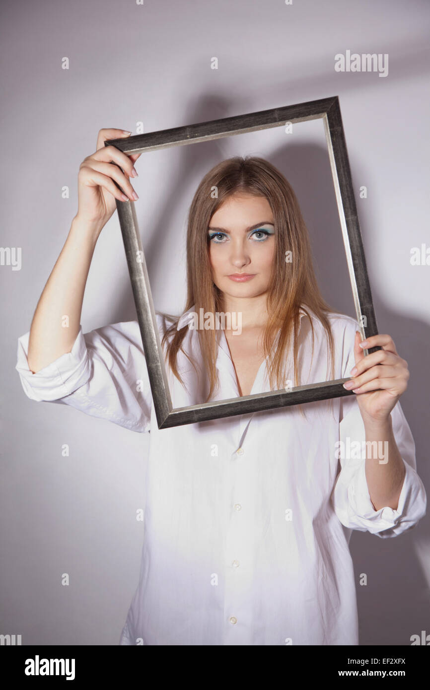 Traurig schöne Mädchen mit einem Rahmen in den Händen Stockfoto