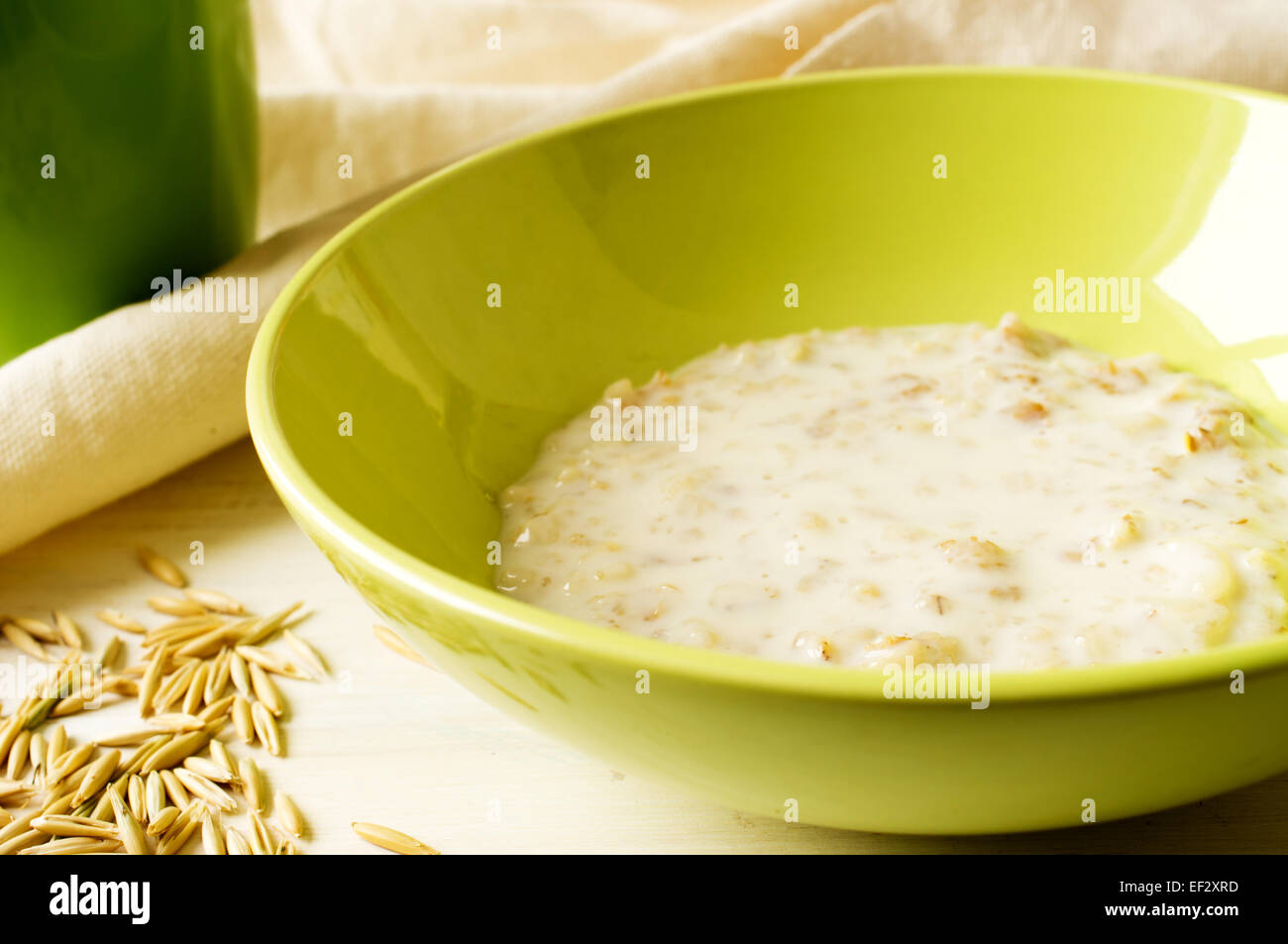 Milchbrei Hafer in einer grünen Schale auf dem Tisch mit Hafer Stockfoto