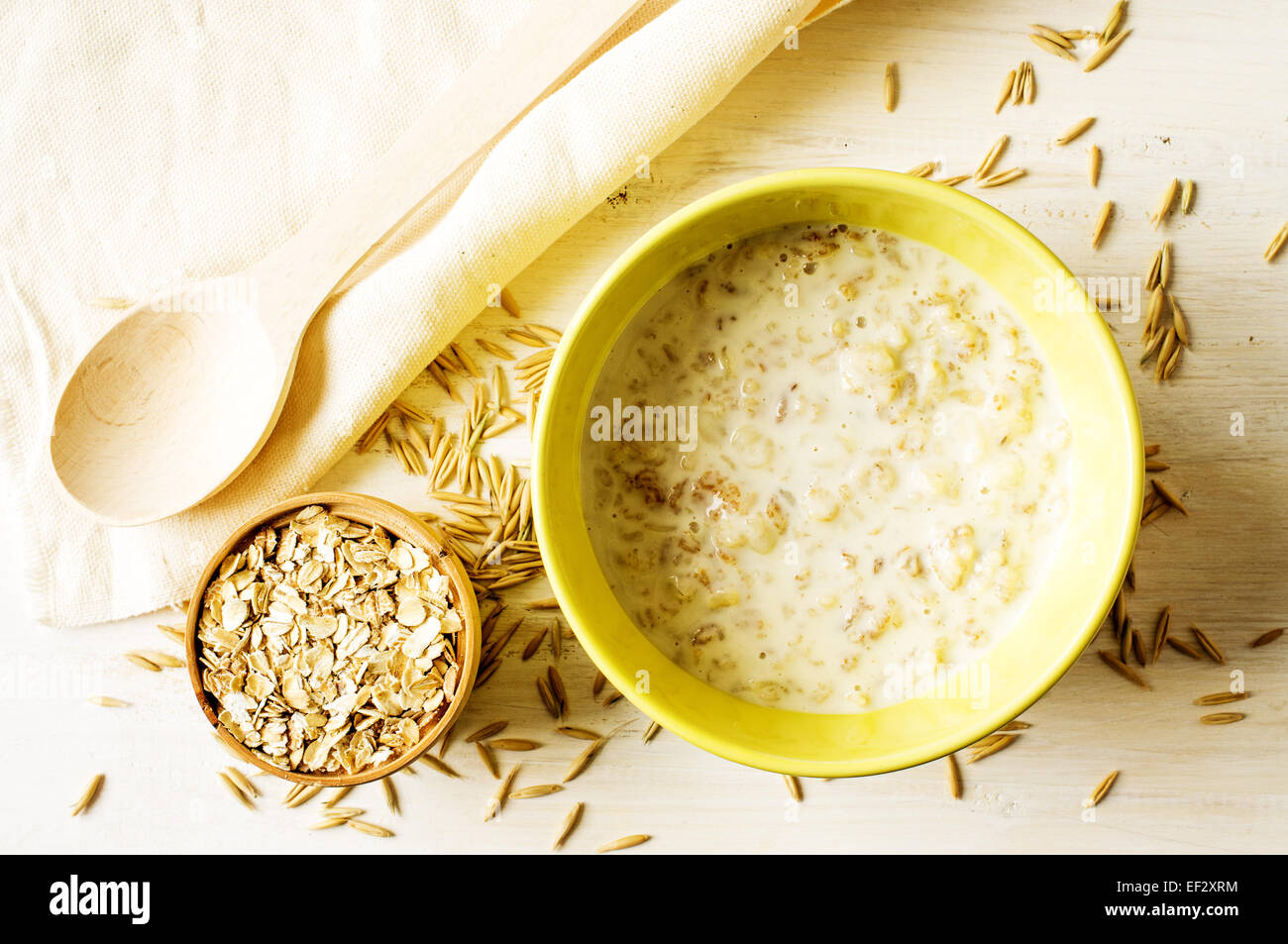 Milchbrei Hafer in einer gelben Schale auf dem Tisch mit Hafer Stockfoto