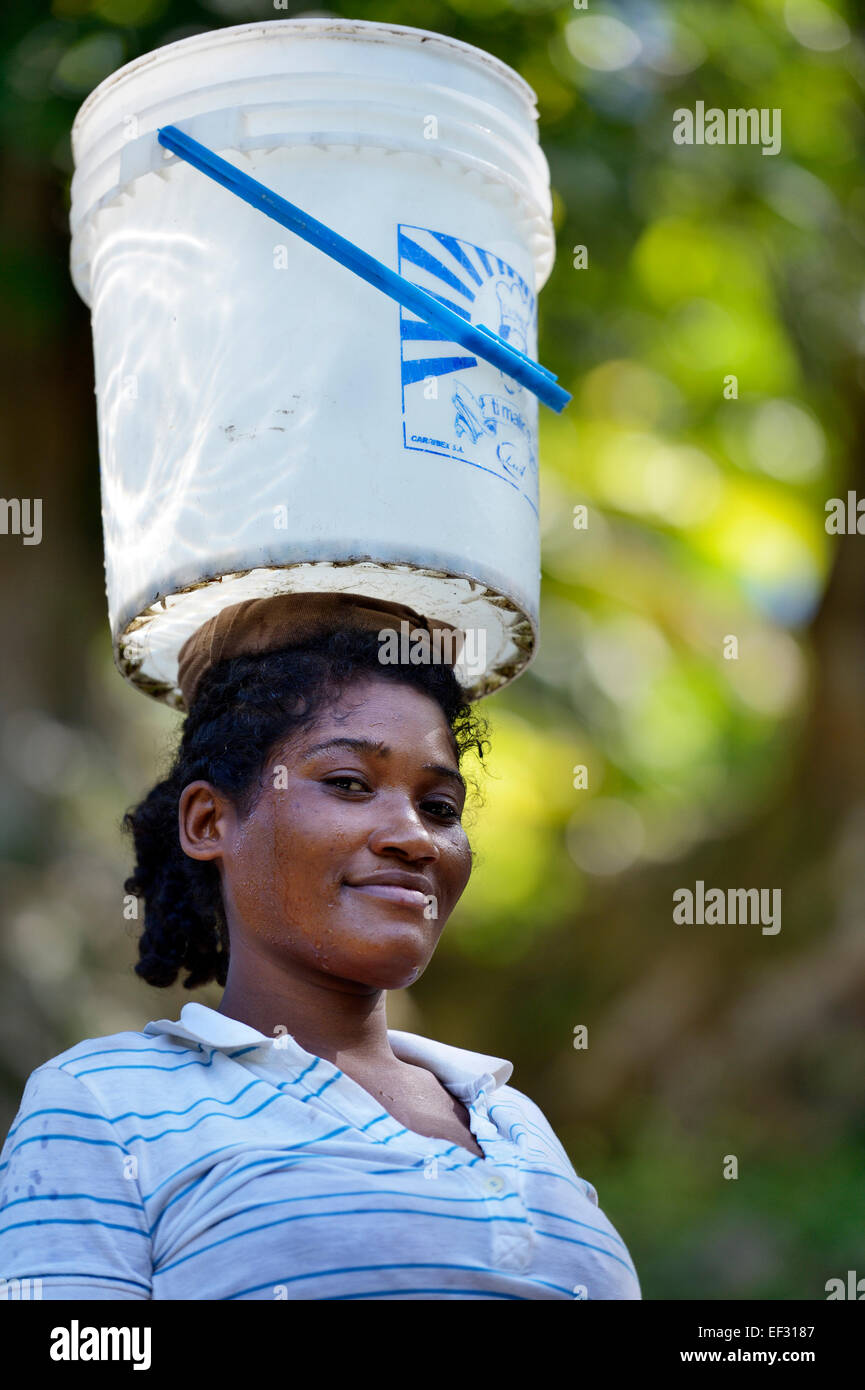 Junge Frau trägt einen Eimer mit Wasser auf ihrem Kopf, Abschied, Sud-Est-Abteilung, Haiti Stockfoto