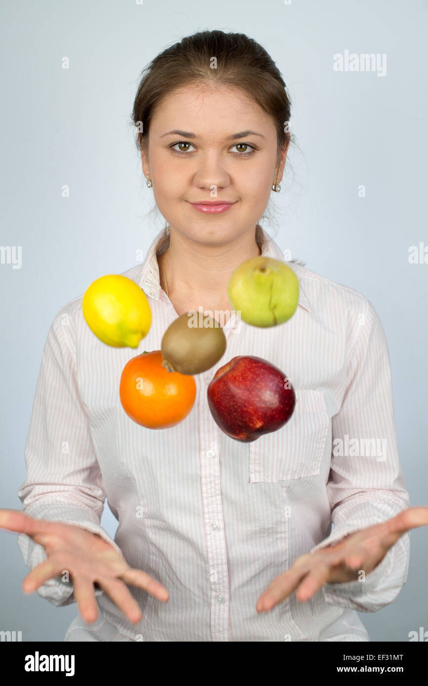 junge Frau tragen Hemd und spielt mit Früchten Stockfoto