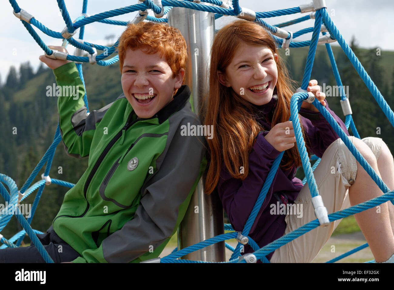 Geschwister, Kinder sitzen in einem Klettergerüst auf dem Spielplatz am Jagahüttn Auf der Sutten, Tegernseer Berge Stockfoto