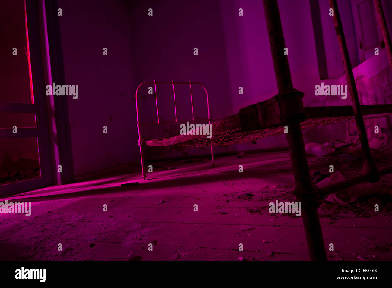 Licht in rosa verlassenen Bett im dunklen Raum gemalt. Halloween-Party-Hintergrund Stockfoto