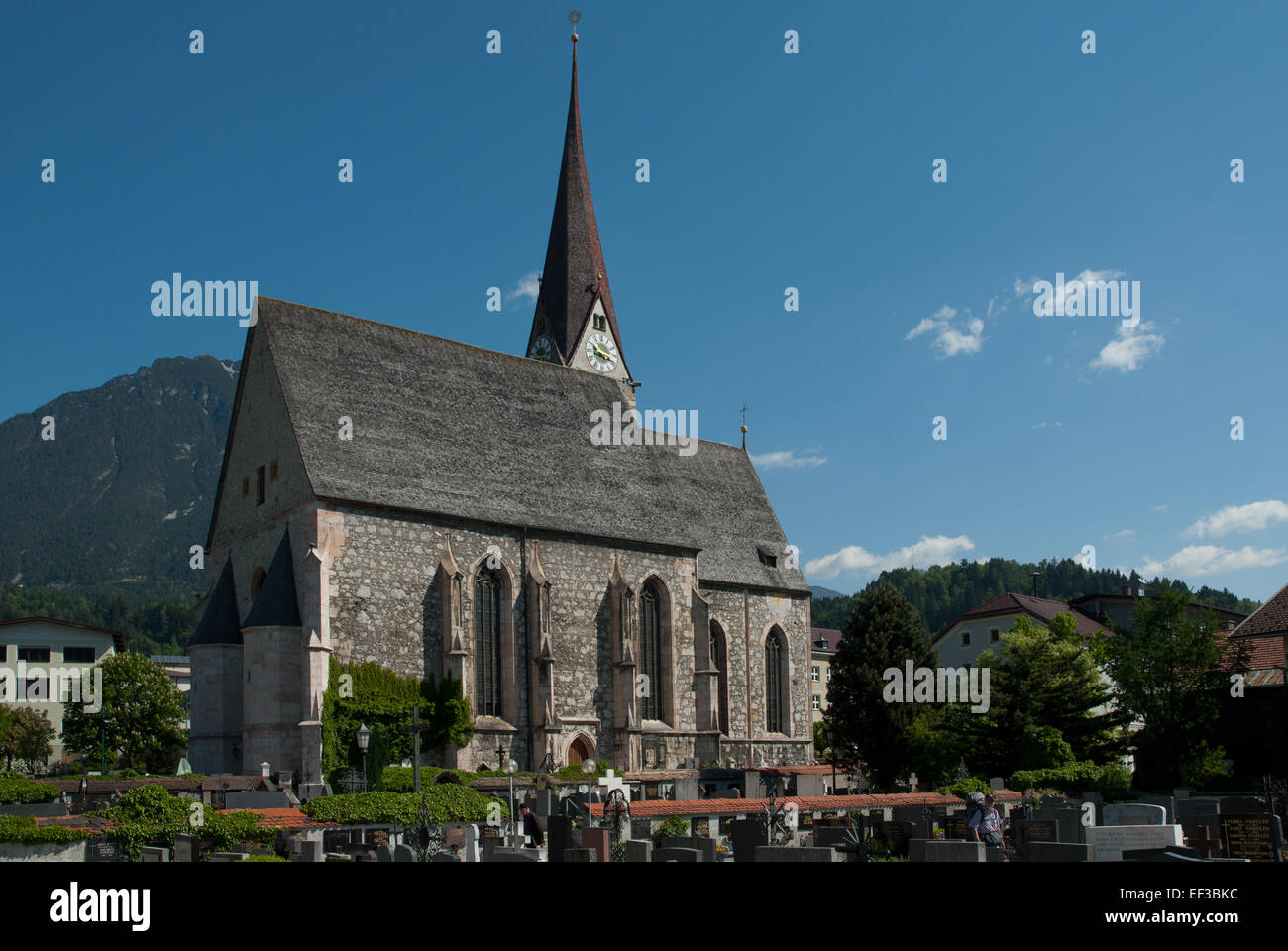 Horizontale Sicht auf die Pfarrkirche in Jenbach, Österreich. Diese Kirche, ein herausragendes Merkmal der Stadt, ist ein Zeugnis des religiösen und architektonischen Erbes der Region und zeigt historische religiöse Architektur. Stockfoto
